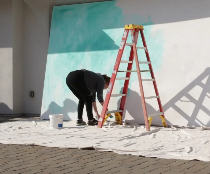 Amy Donaldson priming a nine-by-twenty-foot canvas